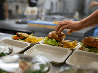 This scenario captures a moment of active food preparation and positive interaction in a professional kitche