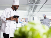 This image focuses on the collaborative, hands-on food preparation often seen in shared commercial kitchens.
