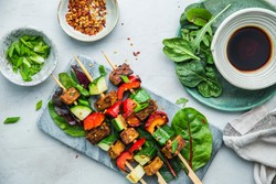 Grilled vegetarian skewers with assorted vegetables, served with sauce and seasonings