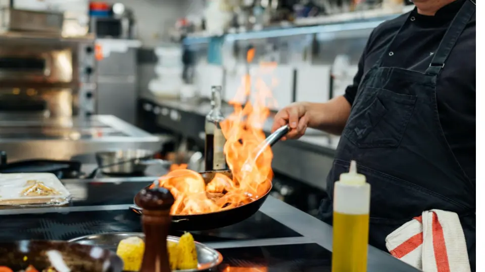 This image captures a high-energy moment of professional culinary skill.